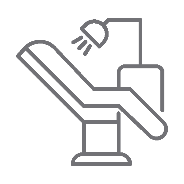 Dental chair with overhead light and suction tool in clinical setting.